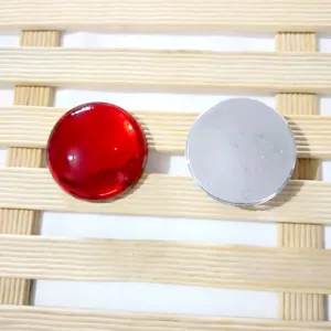 Primo piano di cabochon in acrilico da 40mm rossi e argentati per gioielli fai da te.