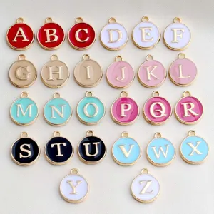 Close-up of colorful round enamel letter charms, double sided DIY jewelry making pendants.
