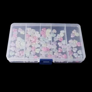 Clear detail shot of transparent compartment storage box filled with colorful heart-shaped crackle beads.