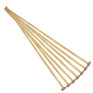 Golden flat head pins for DIY jewelry making, detail view of metal crafting accessories.