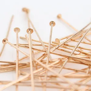 Close-up detail of gold head pins for DIY jewelry making, showing fine metallic texture.