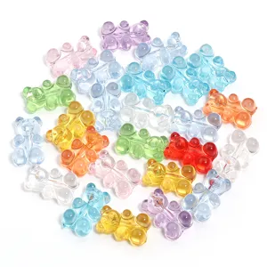 Primer plano de dijes de osito acrílicos transparentes de colores para hacer bisutería y manualidades.