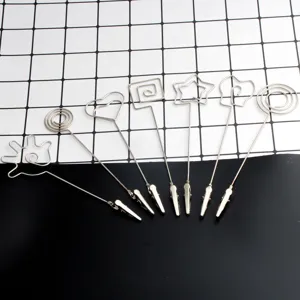 Detalle de portanotas de metal con varias formas creativas de alambre y pinzas decorativas.