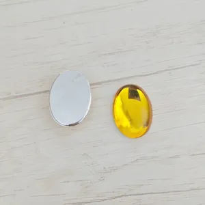 DIY acrylic flatback gemstone detail showing smooth oval shape and vibrant yellow finish.