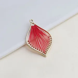 Gouden blad vorm DIY sieraden hanger met rood geweven draad detail voor handwerk.