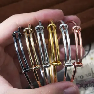 Close-up of adjustable wire bangles in assorted metallic colors, showcasing flexible stacking design.