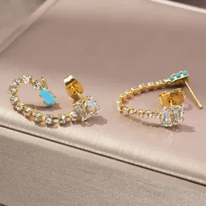 Close-up opname van vergulde zirkonia oorknopjes met mooie turquoise steendetails