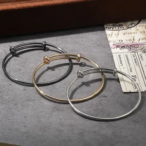 Adjustable wire bangles set in black, gold, and silver. Versatile minimalist metal bracelets.