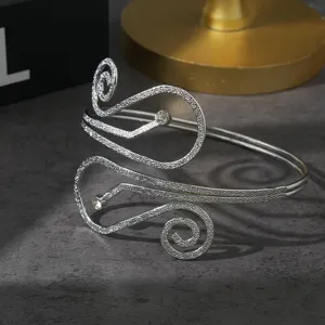 Gedetailleerd overzicht van de stijlvolle zilveren metalen armmanchet met chic spiraalontwerp.