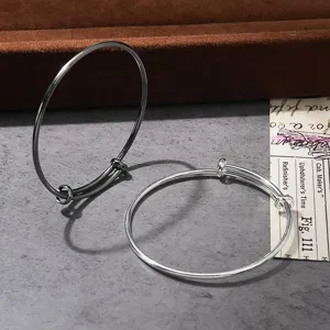 Adjustable wire bracelet detail shot, showing black and silver metal bangle variants clearly.