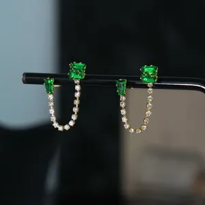 Prachtige vergulde groene zirkonia dubbele ketting oorbellen detailshot, stijlvol en sprankelend.