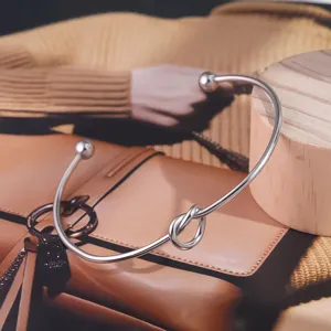 Brazalete abierto de acero de titanio con nudo para mujer, joya elegante y minimalista chic.