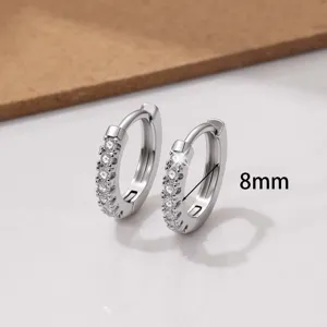 Gedetailleerde macrofoto van 8mm pave zirkonia oorbellen met fijne koperen setting.