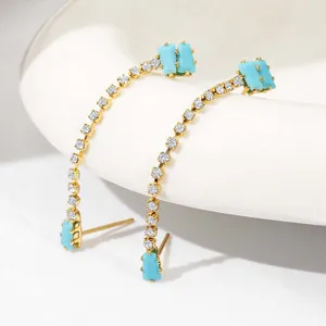 Elegante lange vergulde oorbellen met sprankelende zirkoniasteentjes en turquoise accenten.