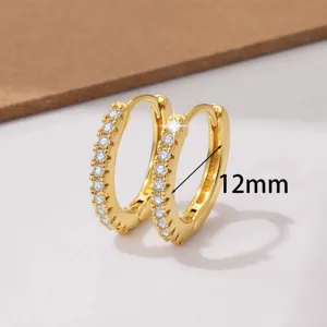 Detailopname van kleine gouden 12mm oorbellen met zirkonia stenen, delicaat stijlvol ontwerp.