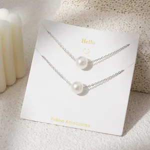 Gedetailleerde close-up van dubbellaagse parelketting ketting op witte displaykaart
