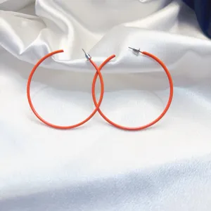 Oranje gelakte metalen creolen, groot rond ontwerp, perfect voor dagelijkse modegeweten.