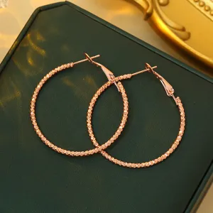 Gedetailleerd overzicht van getextureerde roségouden creolen voor dames, elegant.