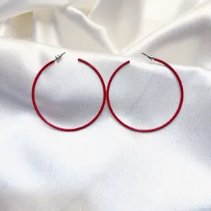 Detail van rode creoolse oren, minimalistisch metalen cirkel design voor dagelijkse mode.