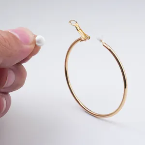 Gedetailleerd overzicht van grote vergulde metalen oorbellen met siliconen stoppers.