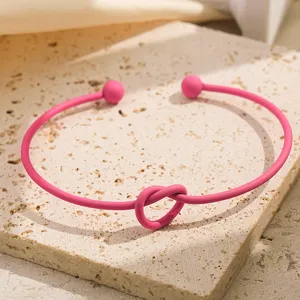 Prachtige roze knoop open armband detail, moderne matte metalen sieraden accessoire.