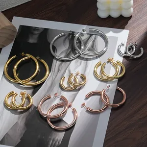 Gedetailleerd overzicht van dikke gouden, zilveren en roségouden creolen, premium metalen finish.