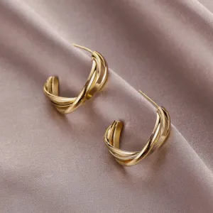 Gedraaide gouden creolen detail, geometrisch C-vormig ontwerp, retro Franse stijl sieraden.