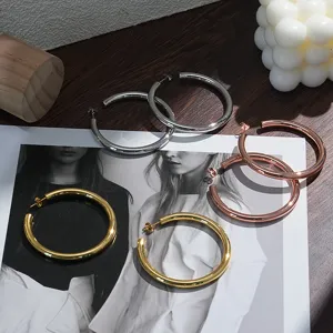 Gedetailleerd overzicht van grote creolen in goud, zilver en rosé goud van messing.