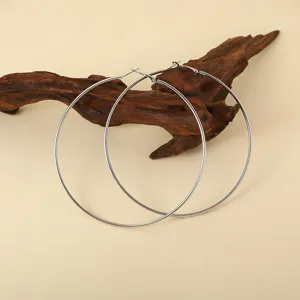 Grote roestvrijstalen oorringen detailweergave met gladde afwerking en strak design.