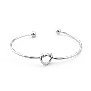 Zilverkleurige open metalen armband met leuk knoopdesign en bal-uiteinden voor vrouwen.