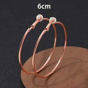 Gedetailleerd overzicht van grote gouden 6cm creolen met fijne metaaltextuur en minimalistisch.