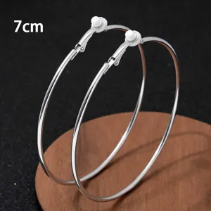 Grote zilveren metalen creolen van 7 cm in close-up, minimalistische geometrische sieradenweergave