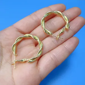 Gouden gedraaide oorbellen hoop detail, stijlvol metalen rond ontwerp, elegante fashion sieraden.