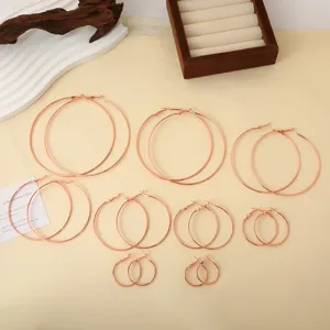 Detailweergave van diverse maten roségouden oorringen netjes op een neutrale achtergrond.