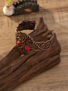 Close-up van vintage punk brede open armband met prachtig snijwerk en opvallende rode stenen.