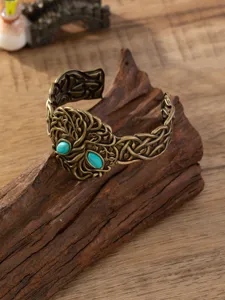 Vintage punk uitgehouwen brede metalen manchetarmband met turquoise stenen detail close up.