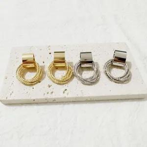 Detailopname van stijlvolle metalen multi-ring oorbellen in gouden en zilveren afwerking.