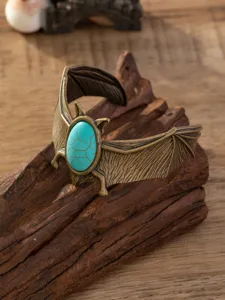 Close-up detail van vintage punk stijl vleermuis vleugel manchet armband met turkoois.