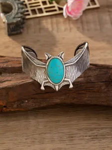Vintage punk stijl vleermuis manchetarmband voorzien van getextureerde turquoise ovale steen.