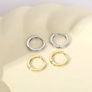 Gedetailleerde close-upopname van minimalistische metalen creolen in zilver en goud.