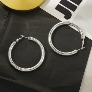 Minimalistische dikke zilveren C-creolen oorbellen voor dames, messing sieraden detail.