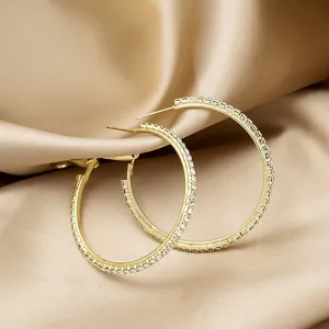 Gedetailleerd overzicht van gouden strass creolen, sprankelende kristallen sieraden.
