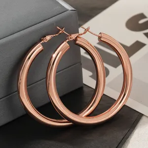 Detail van roségouden dikke C-vormige oorbellen, minimalistisch hol ontwerp voor dames.