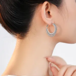 Prachtige detailfoto van holle metalen creooloorringen, elegante zilveren mode sieraden.