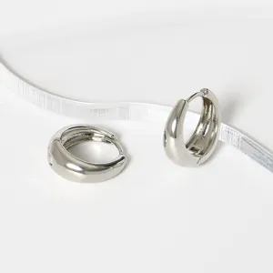 Minimalistische gladde geometrische metalen oorbellen detail, stijlvolle zilveren look.