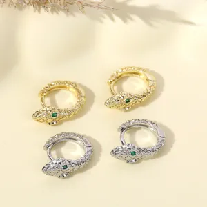 Chique slang oorbellen met groene kristallen ogen, verkrijgbaar in goud en zilver, stijlvol.