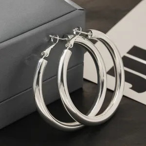 Elegante dikke zilverkleurige C-vormige oorringen voor dames, minimalistisch mode-sieraad design.