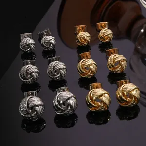 Elegantes pendientes de botón con nudo trenzado de metal, diseño geométrico minimalista.