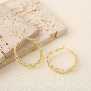 Detailopname van de luxe golvende gouden creolen met fijne metalen textuur voor dames.