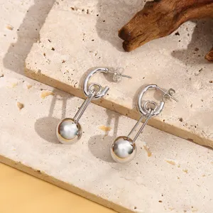 Gedetailleerde close-up van moderne zilverkleurige oorbellen met een strak bolontwerp.